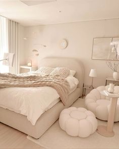 a bedroom with white furniture and decor in the room, including a bed that has been made