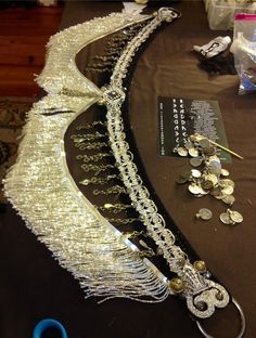 a table topped with lots of different types of necklaces and coins on top of it