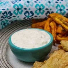 fried fish and french fries on a plate with dipping sauce in a small blue bowl