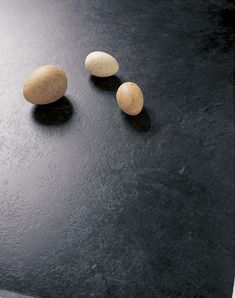 three eggs sitting on top of a black table