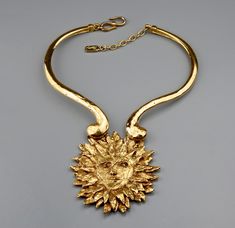 This Vintage Rare YVES SAINT LAURENT Sun Face Necklace is RARE and such a collector item. This was designed by Robert Goossens for YSL and was included in the Metropolitan Arts and Design Museum Exhibition on Fashion Jewelry -- The Collection of BARBARA BERGER. Very classic! A must have. Features: - 100% Authentic YVES SAINT LAURENT. - Adjustable chunky rigid necklace with sun face pendant. - The sun face pendant is intricately detailed, textured and raised. - Signed YSL Made in France. - S and Luxury Vintage Jewelry With Large Stone, Luxury Retro Metal Jewelry, Luxury Art Deco Statement Jewelry, Luxury Bohemian Vintage Jewelry Collection, Luxury Collectible Jewelry With Large Pendant, Luxury Vintage Jewelry With Hallmarks, Luxury Vintage Jewelry For Rodeo, Vintage Couture Jewelry, Luxury Statement Jewelry For Vintage Events