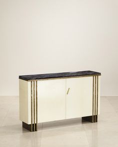 an art deco sideboard with black marble top and gold trimmings on the sides