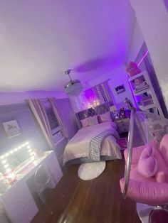 a room with two beds and purple lights on the ceiling, along with a pink chair