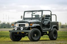 an old jeep is parked in the grass