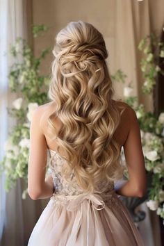 the back of a woman's head with long blonde hair in a wedding dress