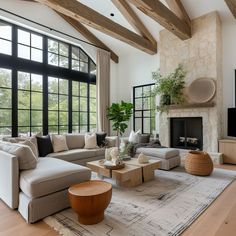 a living room filled with lots of furniture and a fire place in front of a large window