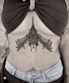 a woman with a bat tattoo on her stomach