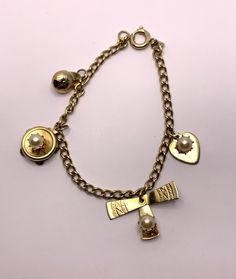 Vintage charm bracelet gold tone metal with 4 cute charms Includes a baseball cap, a heart, a tambourine, a pin wheel Spring ring clasp signed Germany 7 inches length In very good vintage condition. Light wear such as an occasional minor scratch etc... Cheap Round Vintage Charm Jewelry, Vintage Yellow Gold Metal Charms, Yellow Gold Vintage Charm Metal Charms, Yellow Gold Vintage Metal Charms, Yellow Gold Vintage Charms, Yellow Gold Vintage Charm, Vintage Charm Yellow Gold Metal Jewelry, Vintage Charm Jewelry In Yellow Gold Metal, Vintage Gold-tone Jewelry With Logo Charm