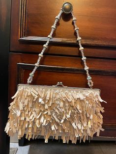 "This appears to have never been used. Truly a One Of A Kind ART DECO Evening Bag. This retro vintage purse is adorned with small white beaded loops with cream beige dangles.  Nice high quality design with a silver tone base and snap closure. The inside is a deep charcoal satin liner. There is an attached clear beaded strap. Inside the purse there is also a silver tone longer cross body chain and extra beading in a plastic bag. A Very eye-catching and extremely well-made bag  9\" W x 5\" L The b Embellished Cream Bags For Events, Cream Rectangular Evening Bag, Embellished Cream Evening Bag, Embellished Cream Rectangular Clutch, Handheld Beaded Beige Evening Bag, Beige Beaded Handheld Evening Bag, Cream Embellished Rectangular Clutch, Formal Embellished Cream Clutch, Cream Handheld Clutch For Party