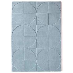 a rug with circles on it in blue and grey colors, against a white background