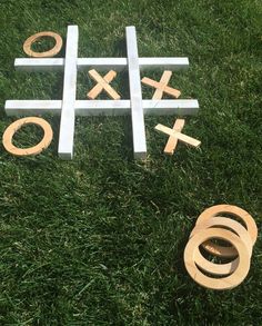 tic - tac - toe game in the grass with wooden pieces and rings