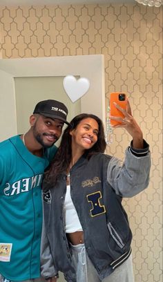 a man and woman taking a selfie in front of a mirror with their cell phones