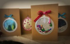 three christmas ornament cards with bows hanging from the front and back of them