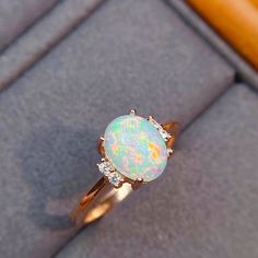 An Elegant and Romantic Ethiopian Opal Ring featuring a shimmering, iridescent opal 8x6 mm accented by sparkling brilliant round diamonds. The ring is handcrafted from 14K Rose gold. As an engagement ring, opals are a perfect representation of the unique spark and fire of your relationship, and their non-replicable nature is a huge draw for those that want a truly one-of-a-kind ring Custom Order: This Ring is offered in different sizes, gold color and the central stone can be upgraded/downgraded Ethiopian Opal Oval Ring For Wedding, Ethiopian Opal Ring For Wedding, White Ethiopian Opal Ring For Promise, White Ethiopian Opal Promise Ring, Yellow Gold Opal Birthstone Promise Ring, Elegant Oval Iridescent Opal Ring, White Ethiopian Opal Ring For Wedding, Ethiopian Opal Promise Ring, White Ethiopian Opal Wedding Ring