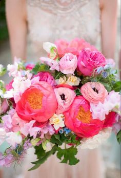 a bride holding a bouquet of pink and white flowers