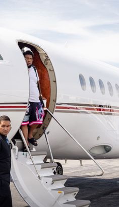 a man walking down the stairs to an airplane