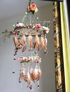 a mobile with flowers and feathers hanging from it