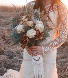 a woman in a white dress holding a bouquet of flowers