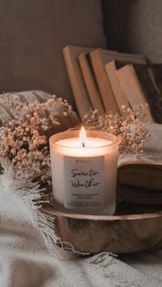 a white candle sitting on top of a wooden tray