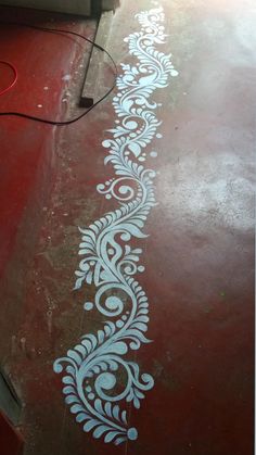 the floor is painted with white stencils on red and gray paint, along with an electrical cord