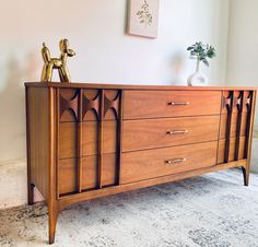 a wooden dresser with two brass faucets sitting on it's sideboard