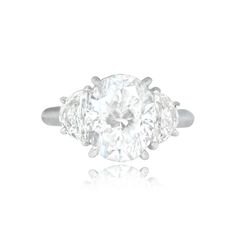 a three stone diamond ring on a white background