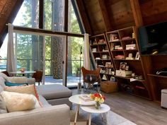 a living room filled with furniture and a flat screen tv on top of a wooden wall