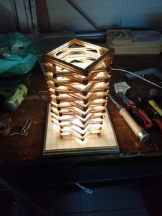 a wooden structure sitting on top of a table next to some tools and paper bags