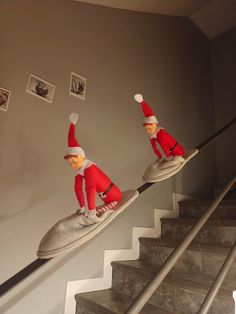 two elfs are riding on top of shoes down the stair case in this house