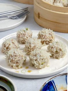 rice balls on a white plate with silverware in the background