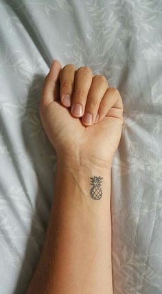 a small pineapple tattoo on the wrist