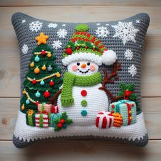 a crocheted christmas pillow with a snowman on it