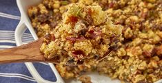 a casserole dish with stuffing and a wooden spoon