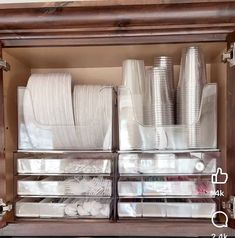 a cabinet filled with lots of white plates and cups