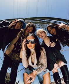 four young women posing for a photo in front of the eiffel tower