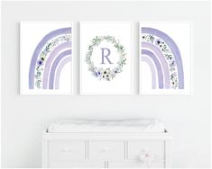 three prints with flowers and rainbows are hanging on the wall next to a crib