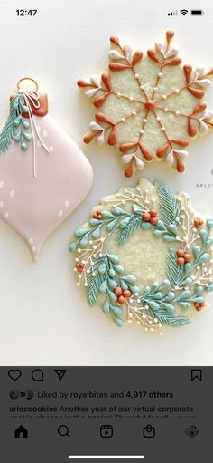 three decorated cookies sitting next to each other on a white counter top with an ornament hanging from it