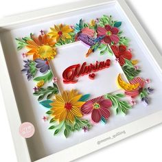 a white frame with some flowers and the word believe in it