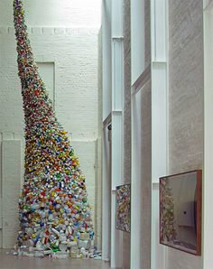 there is a very tall sculpture made out of cans and other things in the room