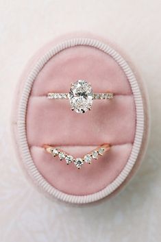 two engagement rings in a pink velvet ring box