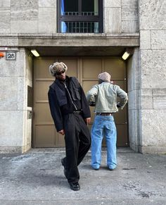 two men standing in front of a garage door