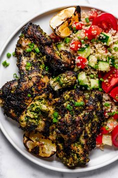 a white plate topped with chicken, rice and veggies