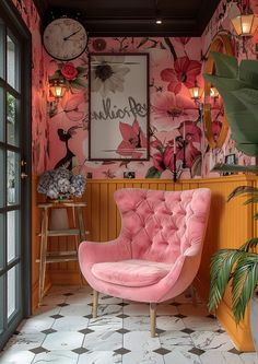 a pink chair sitting in front of a window next to a clock on the wall