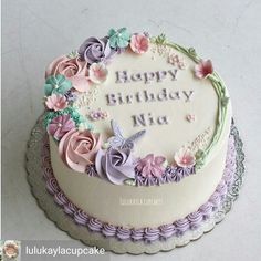 a birthday cake decorated with flowers and butterflies