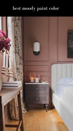 a bedroom with pink walls and wooden floors