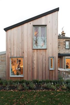 a house that is made out of wood and has two windows on the side of it