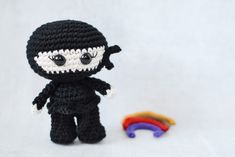 a crocheted doll next to a rainbow toy