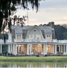 a large white house sitting next to a lake