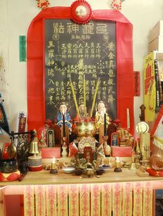 there is a table with many items on it in front of a blackboard and chinese writing