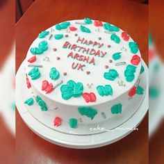 a birthday cake with white frosting and green leaves on it that says happy birthday arrhha uk